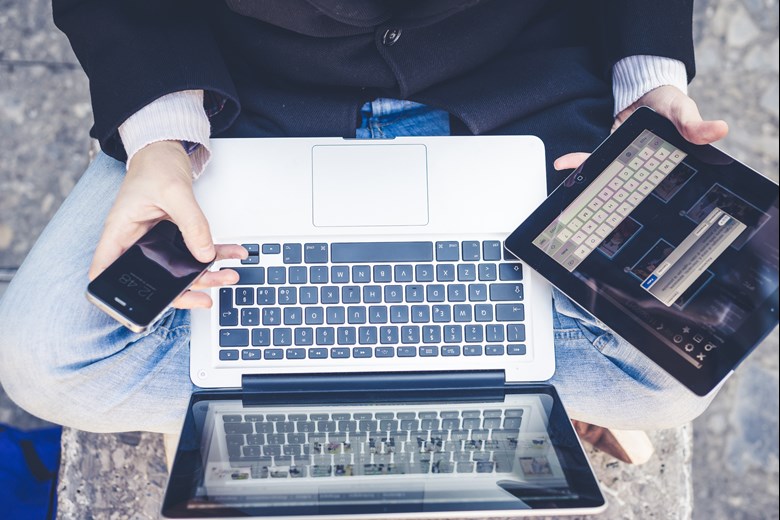 Man with laptop, phone and tablet